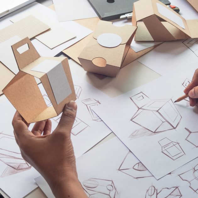 Designer sketching drawing design Brown craft cardboard paper product eco packaging mockup box development template package branding Label . designer studio concept .